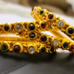 A Jaipur Royal Gemstone Bangle Set, featuring multiple gold-toned bangles adorned with sparkling gemstones.