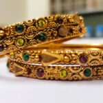 A traditional gold-plated bangle set with intricate designs and vibrant gemstones, perfect for any occasion.