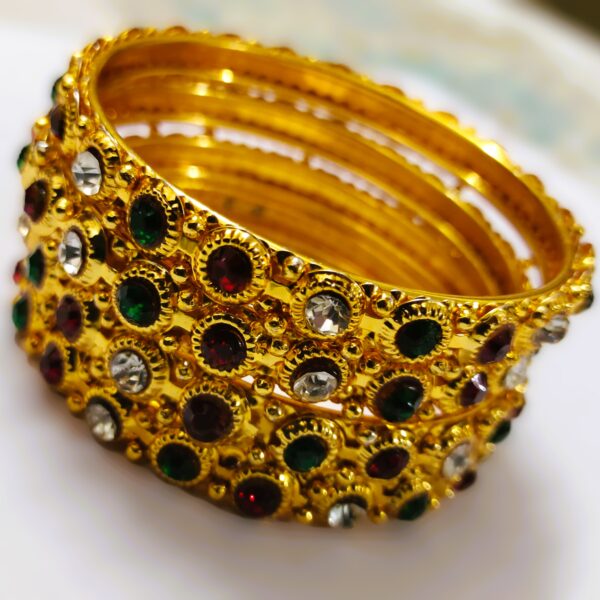 A Jaipur Royal Gemstone Bangle Set, featuring multiple gold-toned bangles adorned with sparkling gemstones.