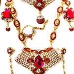 A stunning Rajasthani Bridal Jewelry Set, featuring a necklace, earrings, and a maang tika, adorned with red and white gemstones.