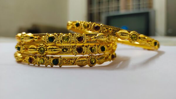 A stunning set of Rajwadi Regal Gold-Plated Bangle Set, adorned with vibrant gemstones and intricate designs.