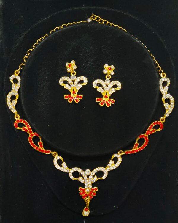 A stunning Jaipur Crimson Rhapsody Bridal Jewelry Set, featuring a necklace, earrings, maang tika, and choker adorned with red and white stones.