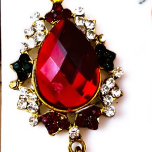 A close-up of the Rajasthani Gold-Plated Bridal Earrings, showcasing the red and white gemstones and gold-plated metalwork.