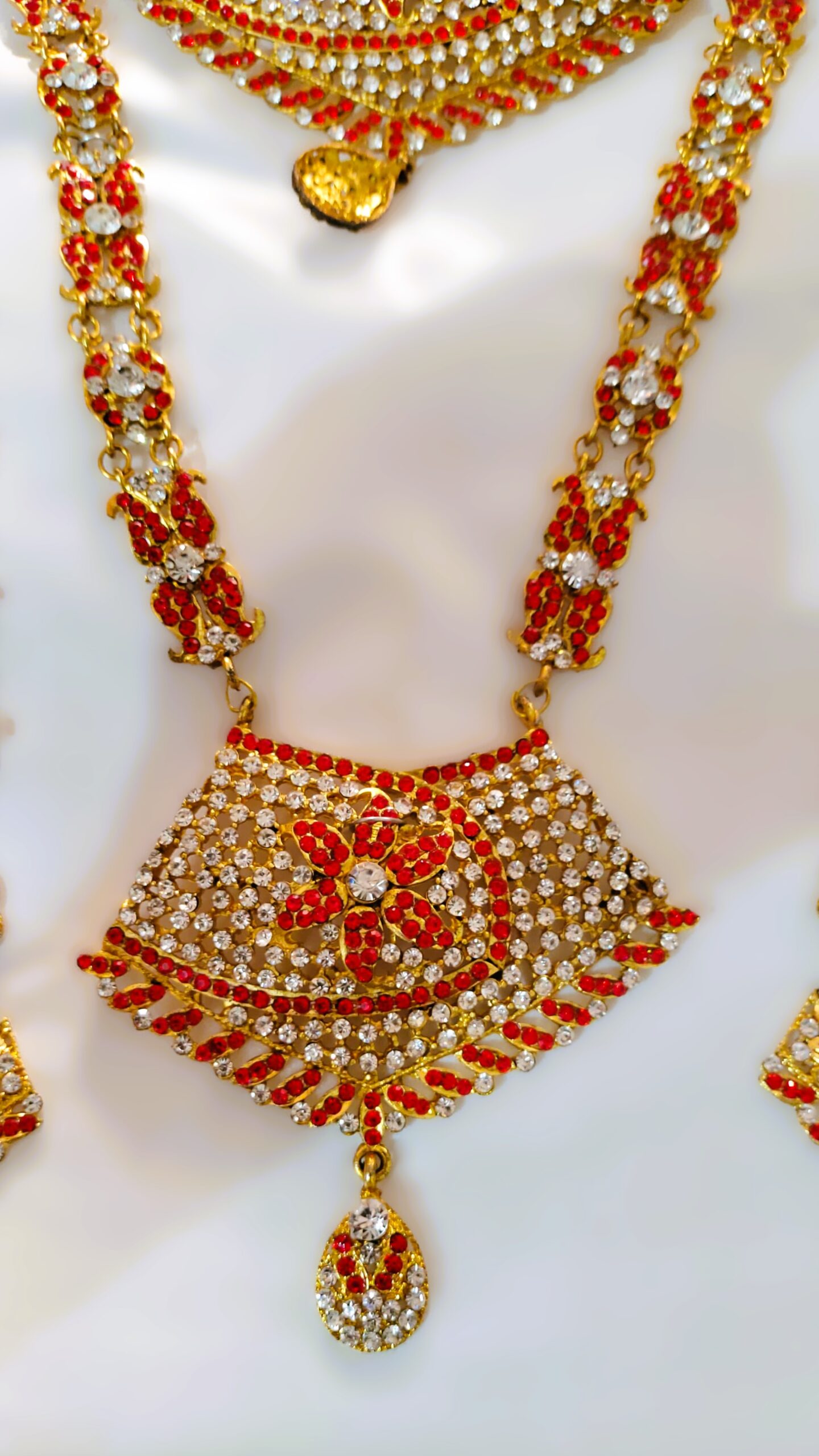 A close-up of the intricate details on the Rajasthani Royal Crimson and Ivory Bridal Necklace, showcasing the crimson and ivory gemstones and gold-plated metalwork.