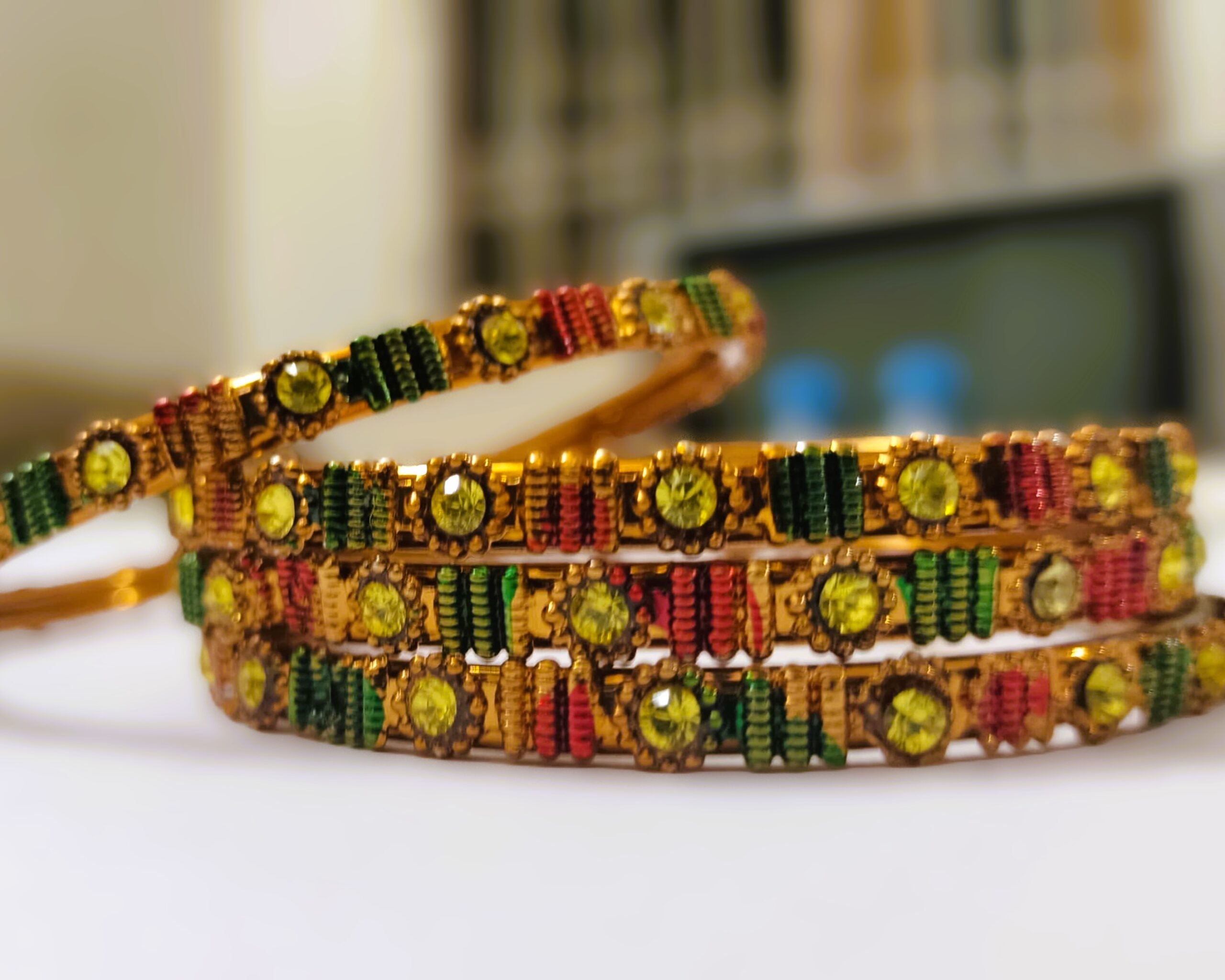 A traditional gold-plated bangle set with intricate designs and vibrant gemstones, perfect for any occasion.