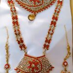 A Rajasthani Royal Bridal Jewelry Set with necklace, earrings, maang tika, and choker, adorned with Kundan and American diamond stones.