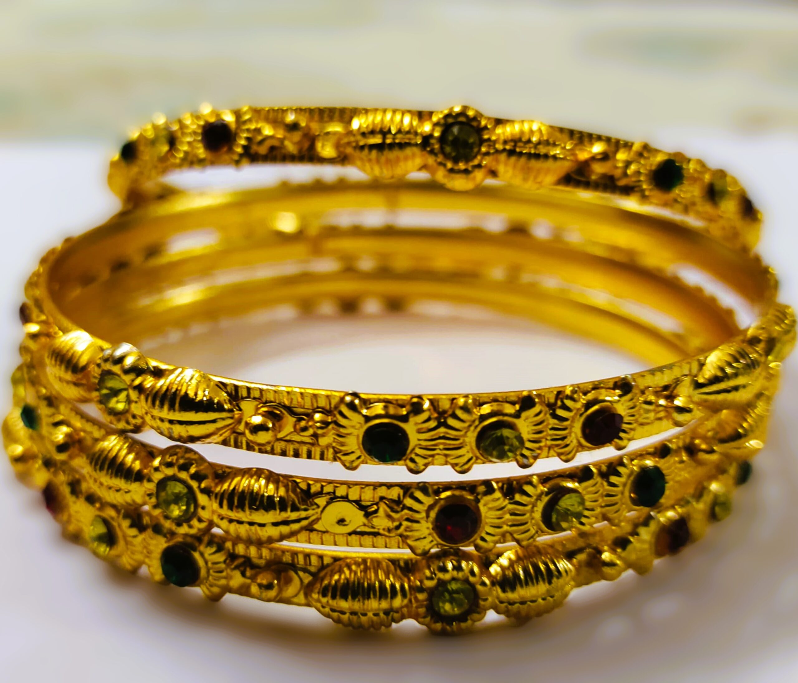 A stunning set of Rajwadi Regal Gold-Plated Bangle Set, adorned with vibrant gemstones and intricate designs.