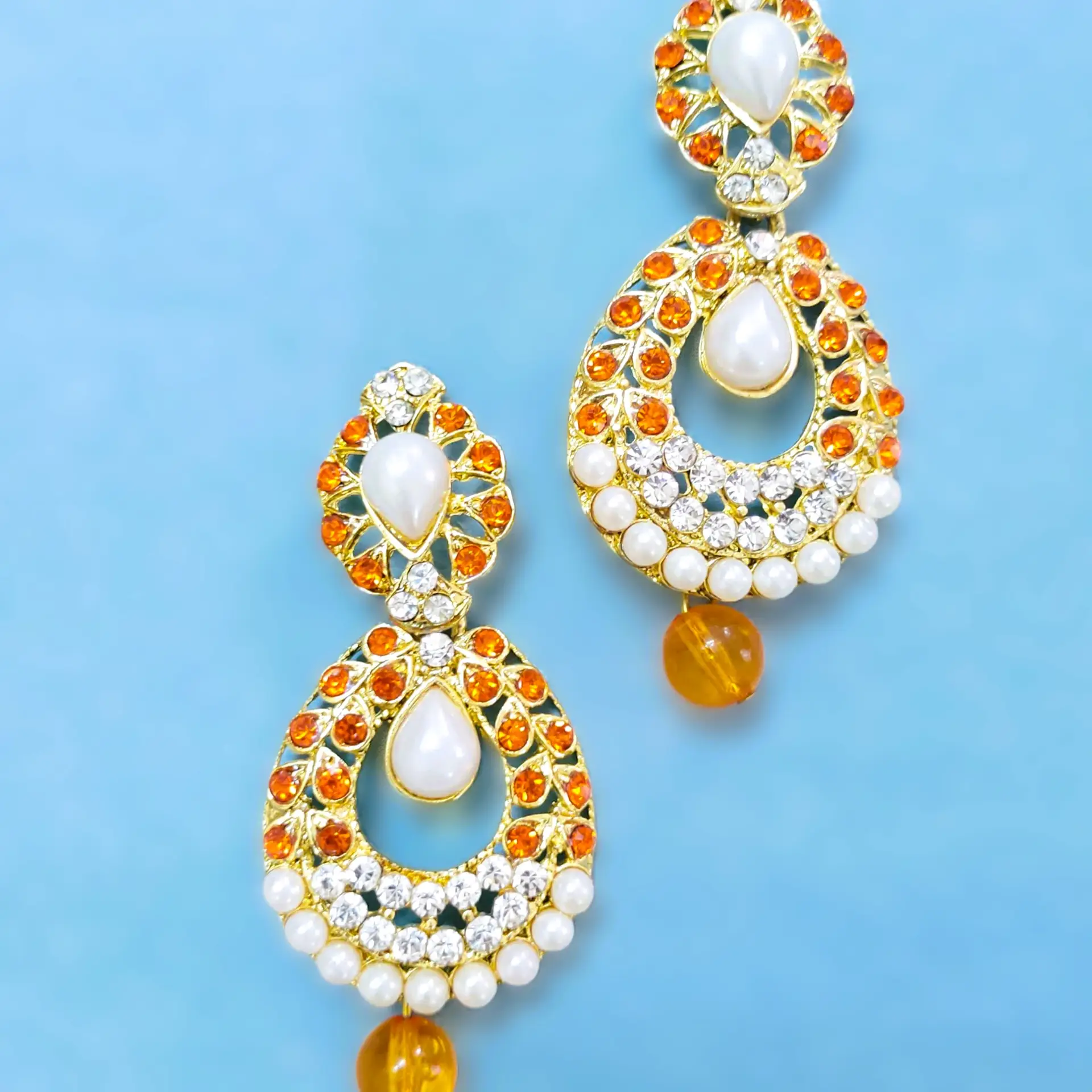 Close-up of the orange stones and pearls on the Rajasthani Gold-Plated Drop Earrings